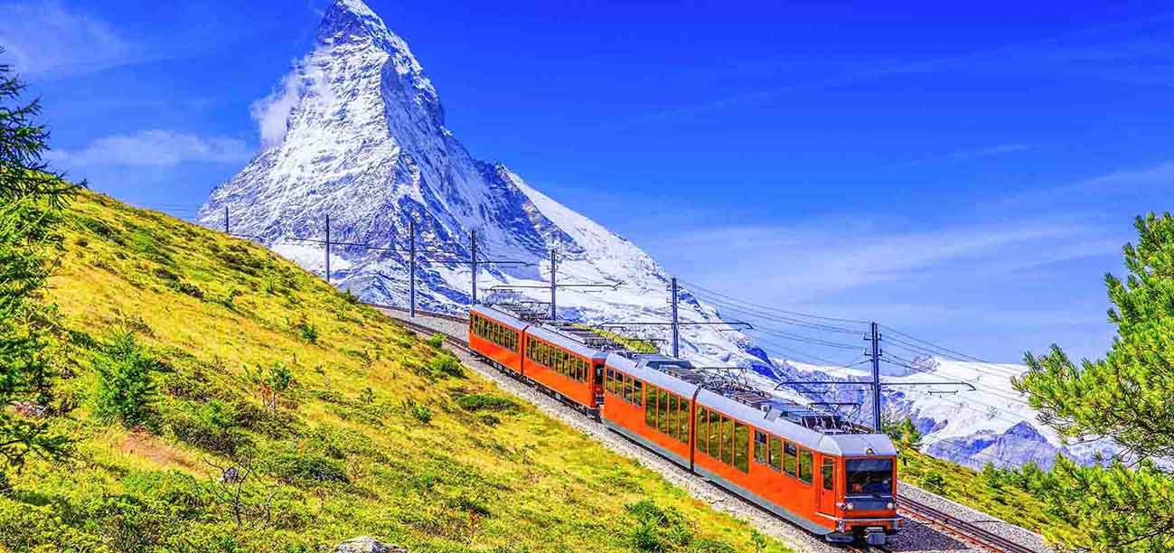 A Swiss red train going through the mountains