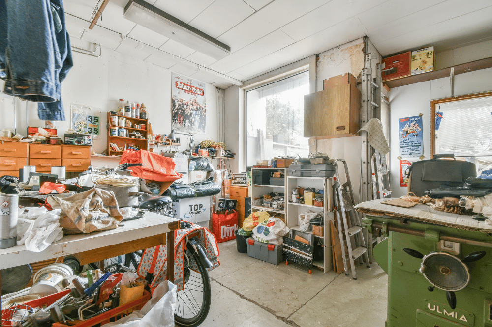 cluttered garage full of tools bikes boxes and garden equipment