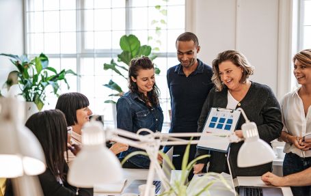 working professional women and a coloured man discussing a presentation
