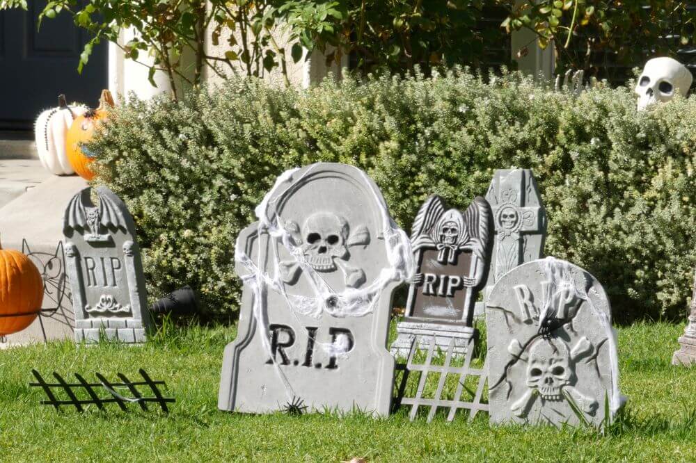 An image of a garden dressed for Halloween with faux tombstones. 