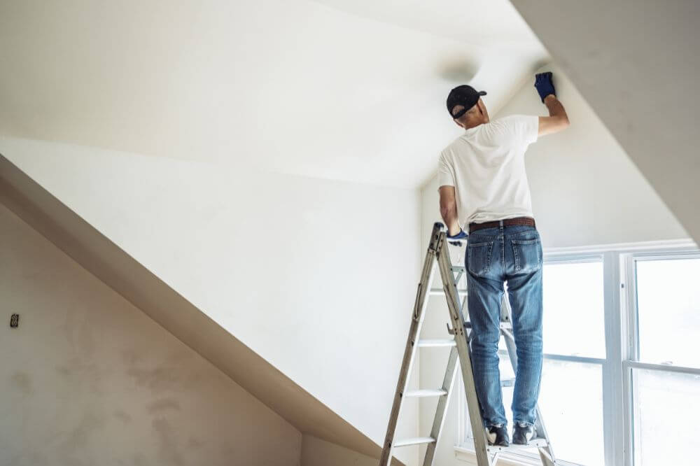 Man painting his new home and making his new space his own on International Men's Day