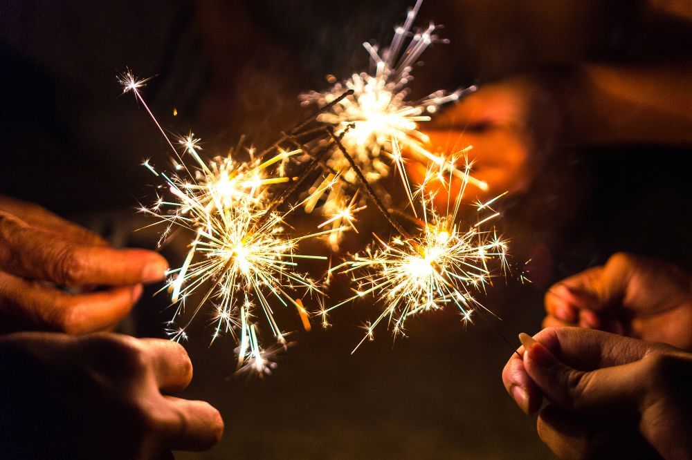 An image of people at a Bonfire Night gathering using sparklers. 