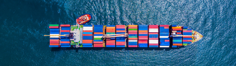 Aerial view of a large cargo container ship transporting shipping containers overseas, representing global logistics and Pickfords Relocation&#39;s international move management services